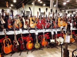 Assorted display of vintage guitars at Guitar Center's booth.